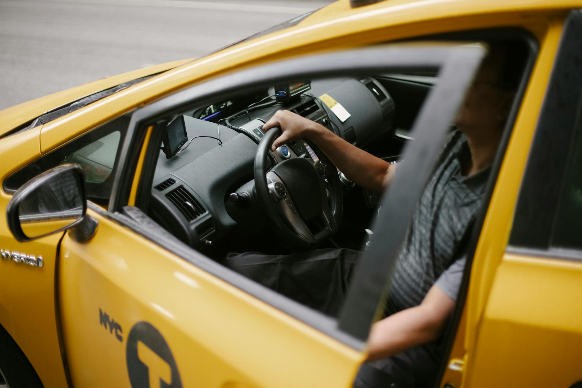 Młody kierowca trzyma kierownicę żółtego auta podczas jazdy