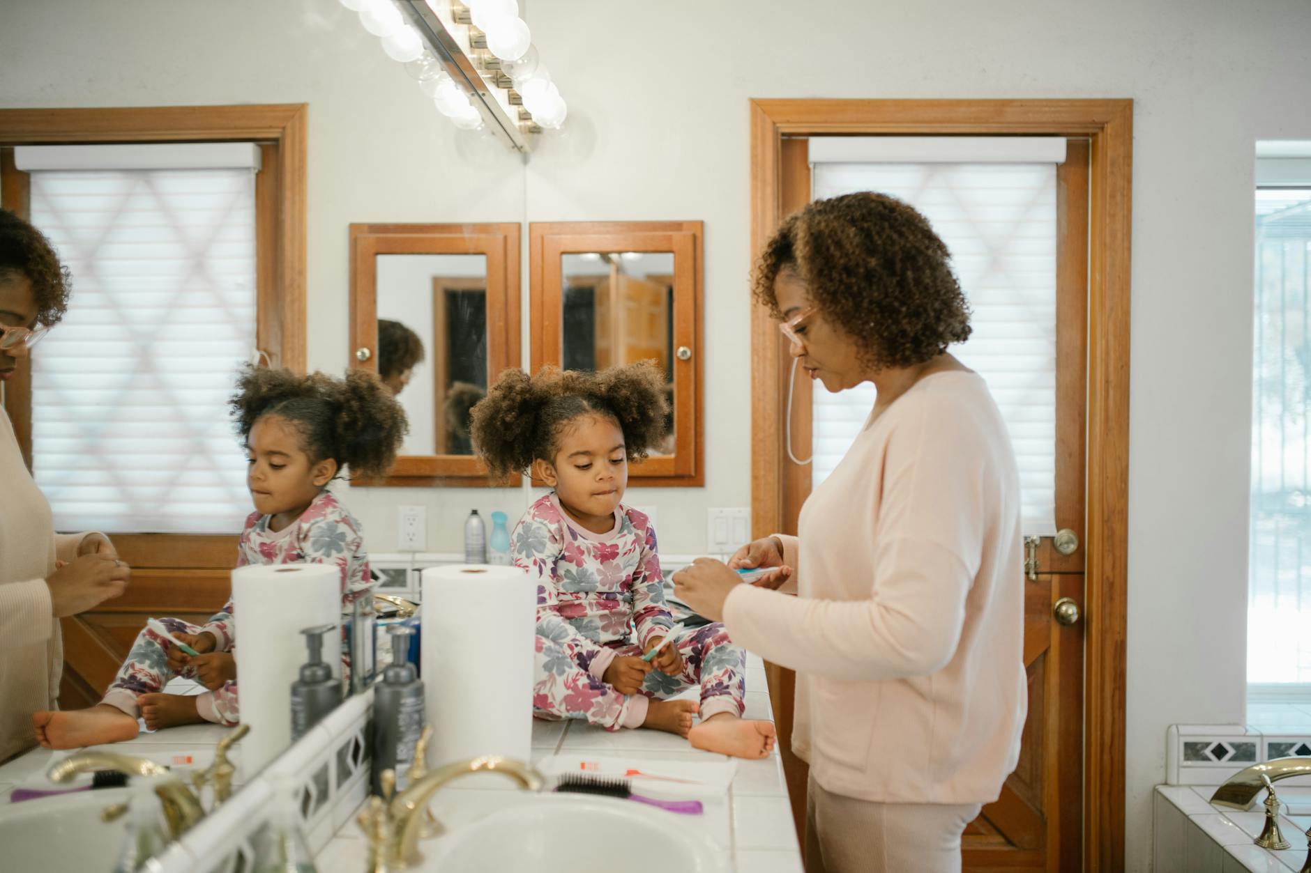 Mama pomaga córce w porannej toalecie w jasnej łazience