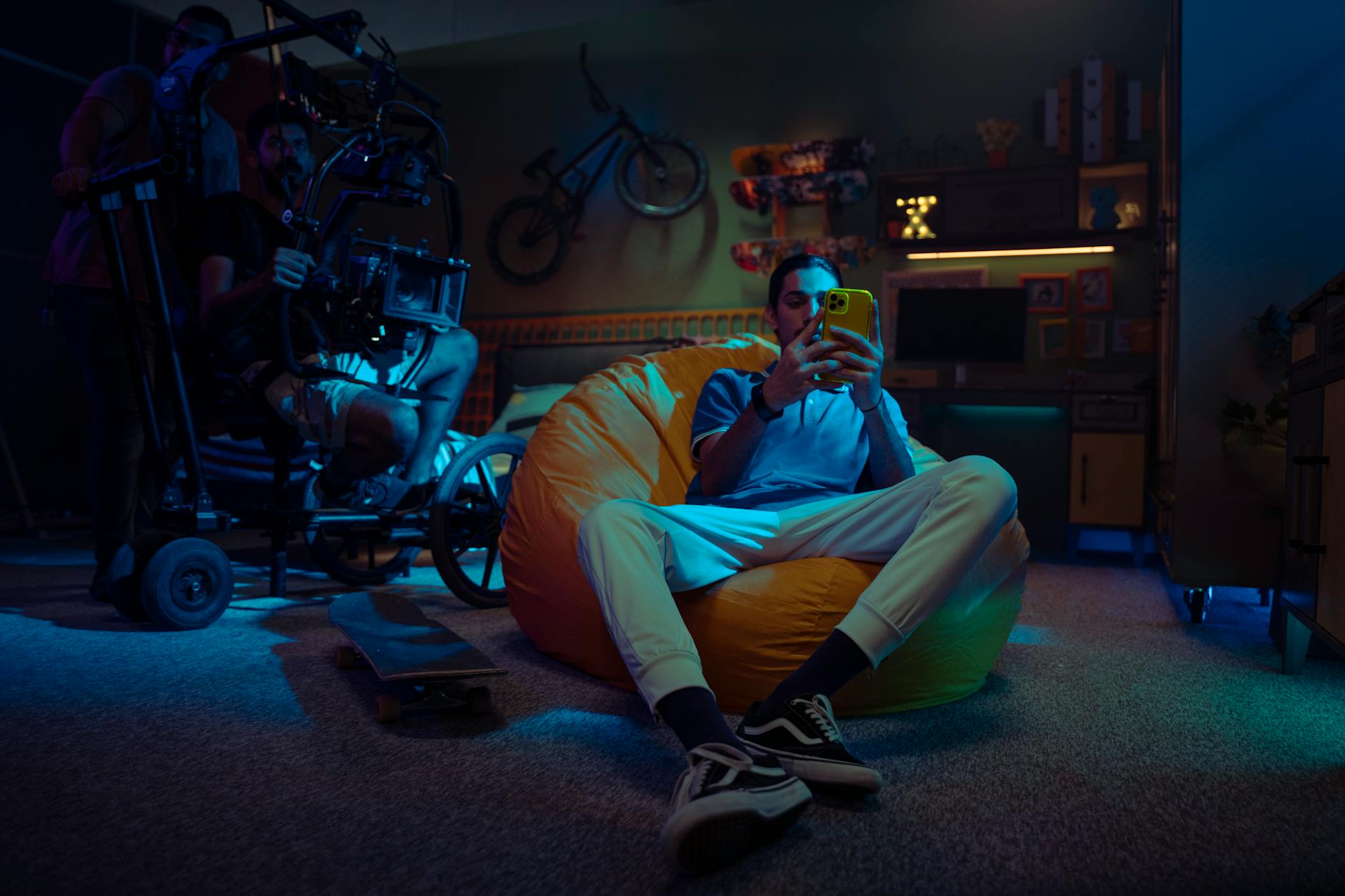 Mężczyzna siedzi na pufie sako i korzysta ze smartfona