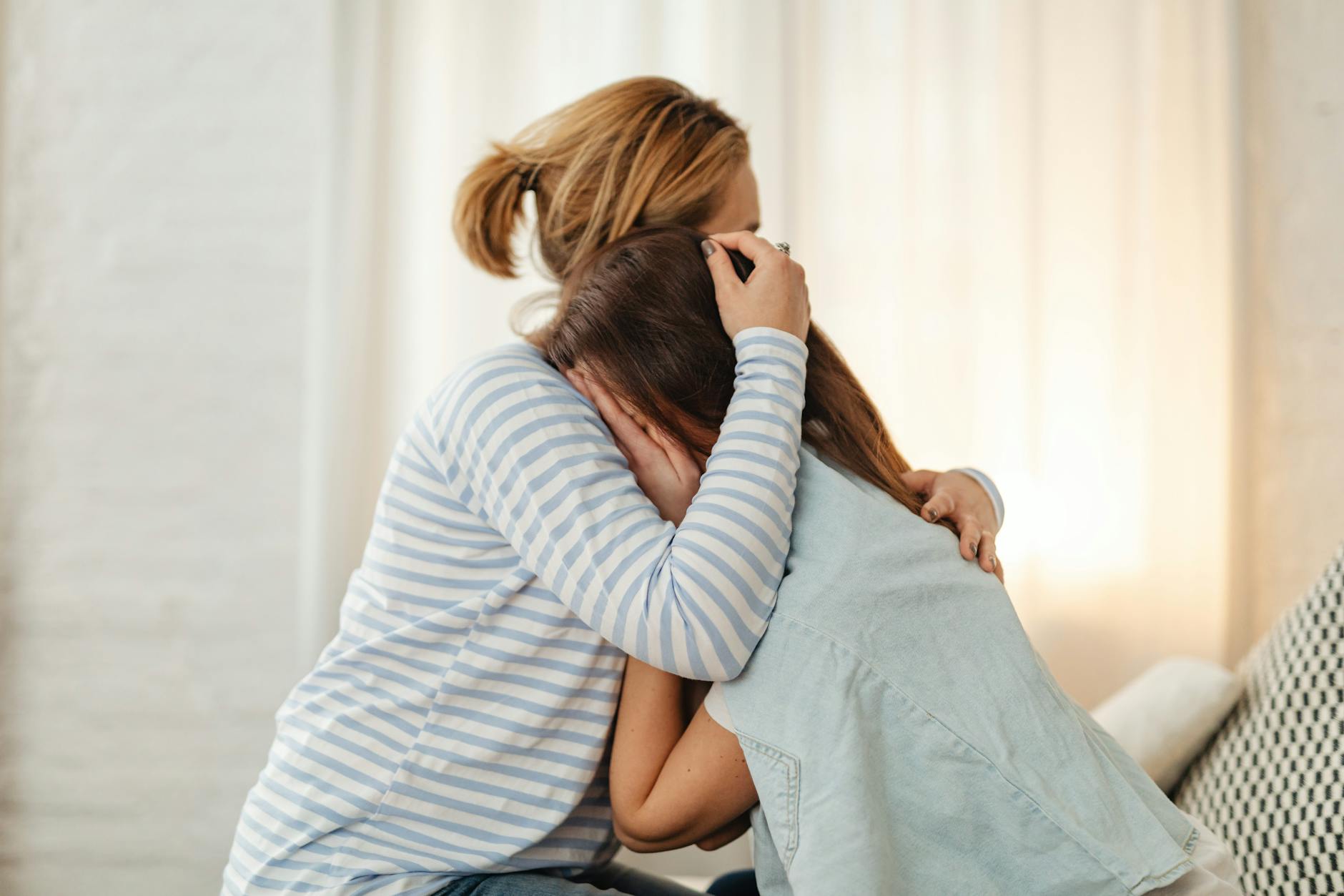 Mama przytula zapłakaną nastolatkę, wspierając ją w trudnym momencie