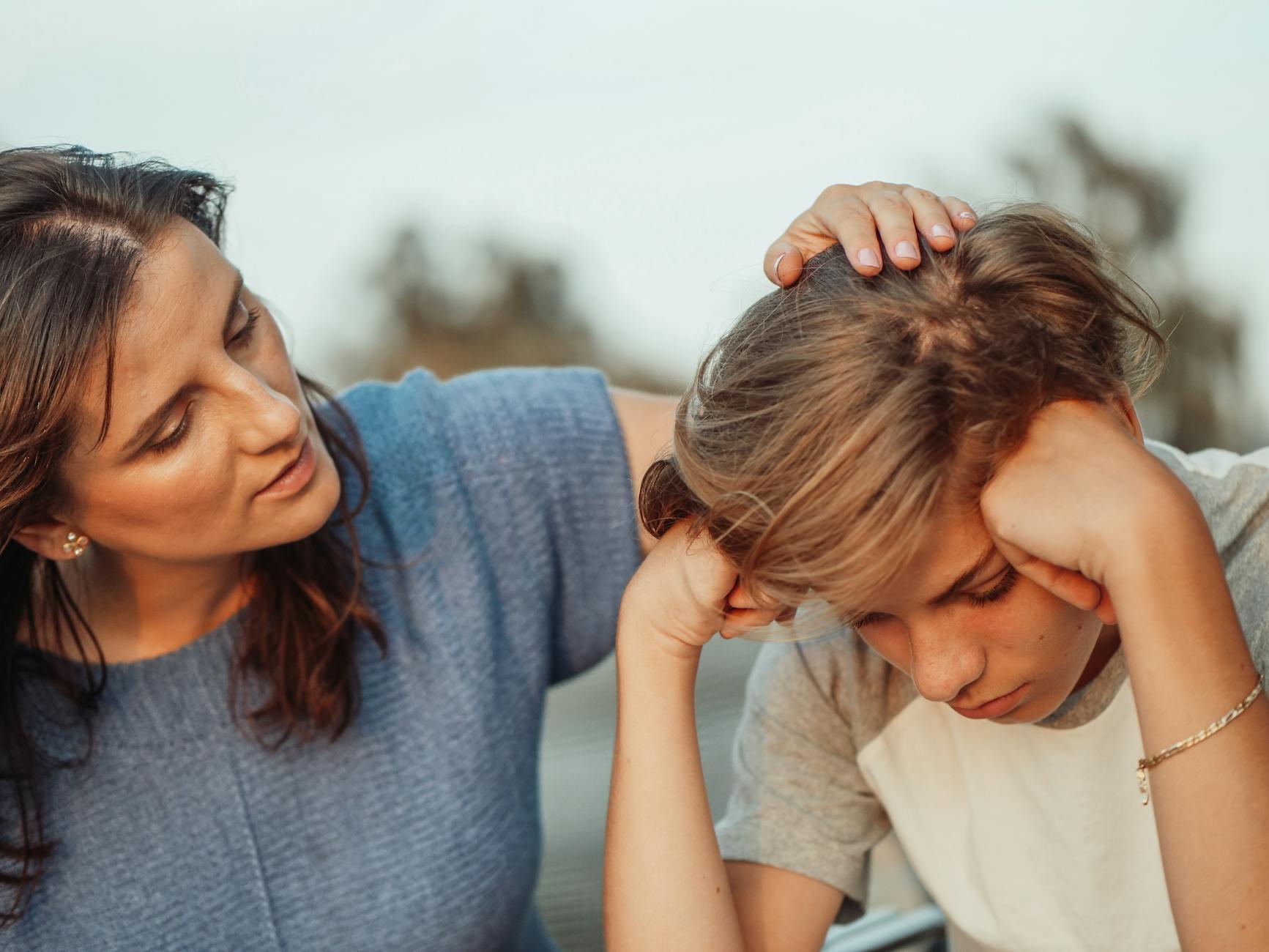 Mama wspierająca zasmuconego nastoletniego syna w domu