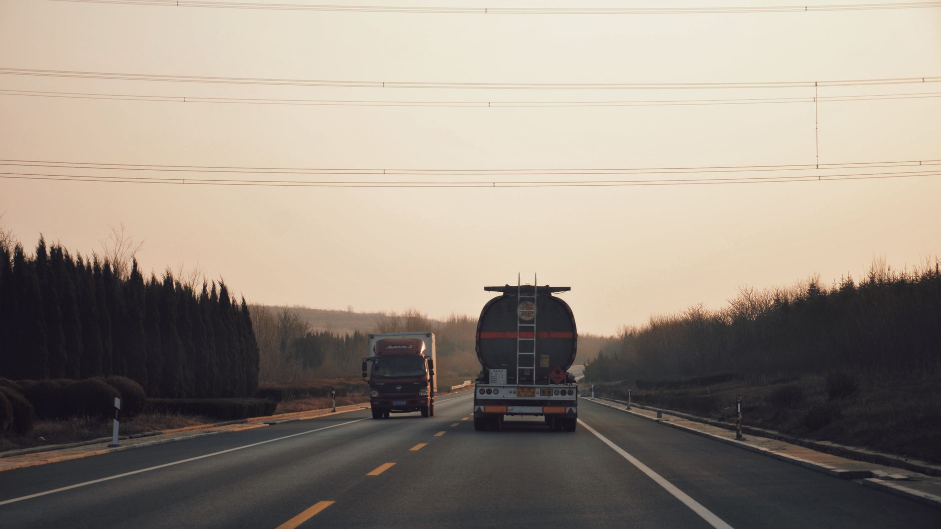 Ciężarówki jadące autostradą o zachodzie słońca